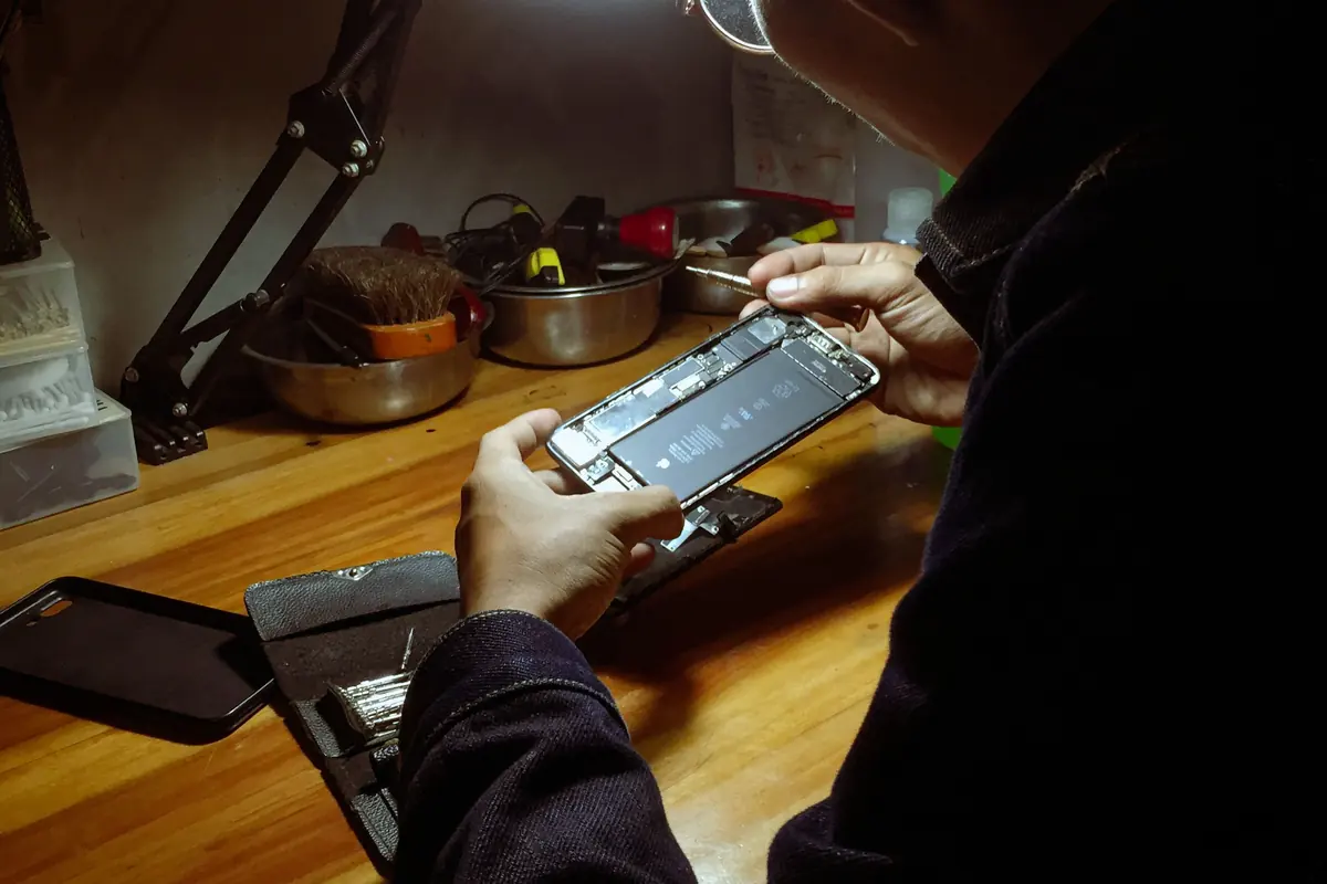 A person working on a phone at a workbench